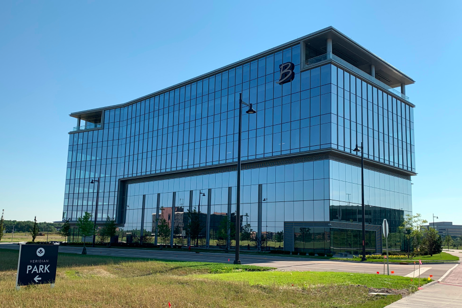 The Boler Company headquarters at 90 North Schaumburg, a stunning glass-clad building surrounded by landscaped paths and open green spaces.