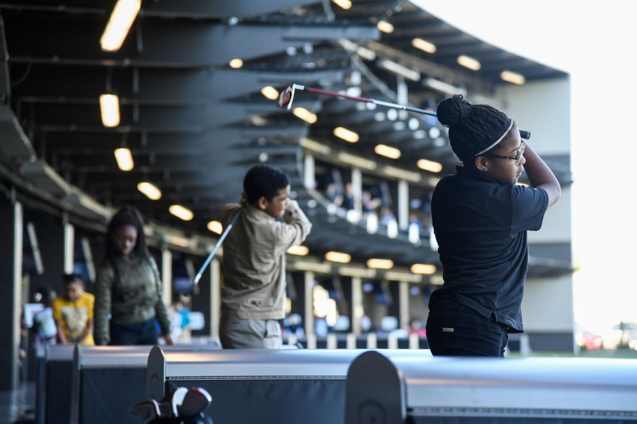 A close up of patrons enjoiying Topgolf Schaumburg's climate controled, interactive golf bays.