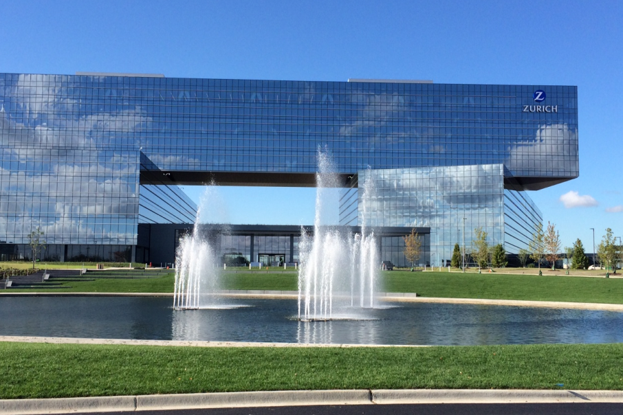 Zurich American Insurance Company headquarters at 90 North Schaumburg, featuring striking glass architecture, a reflecting pond, and open green spaces.